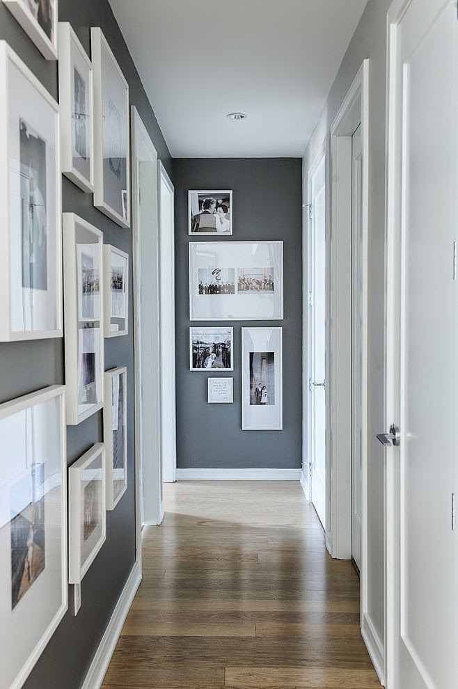Hallway gallery with white framed pictures on the left wall and a few more on the end wall.