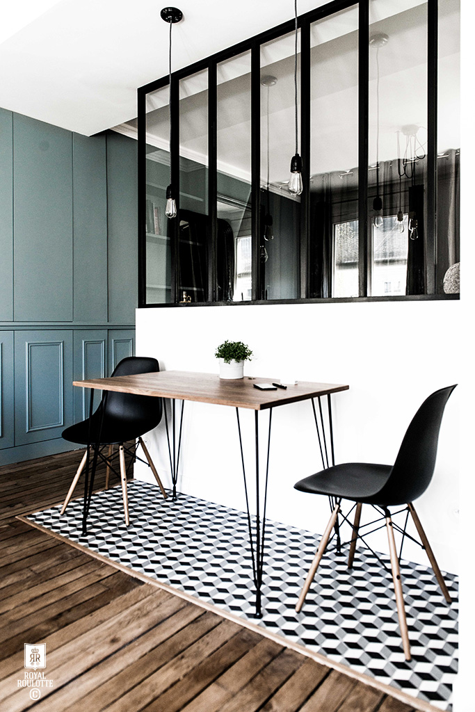 A monochrome kitchen featuring a table and two chairs.