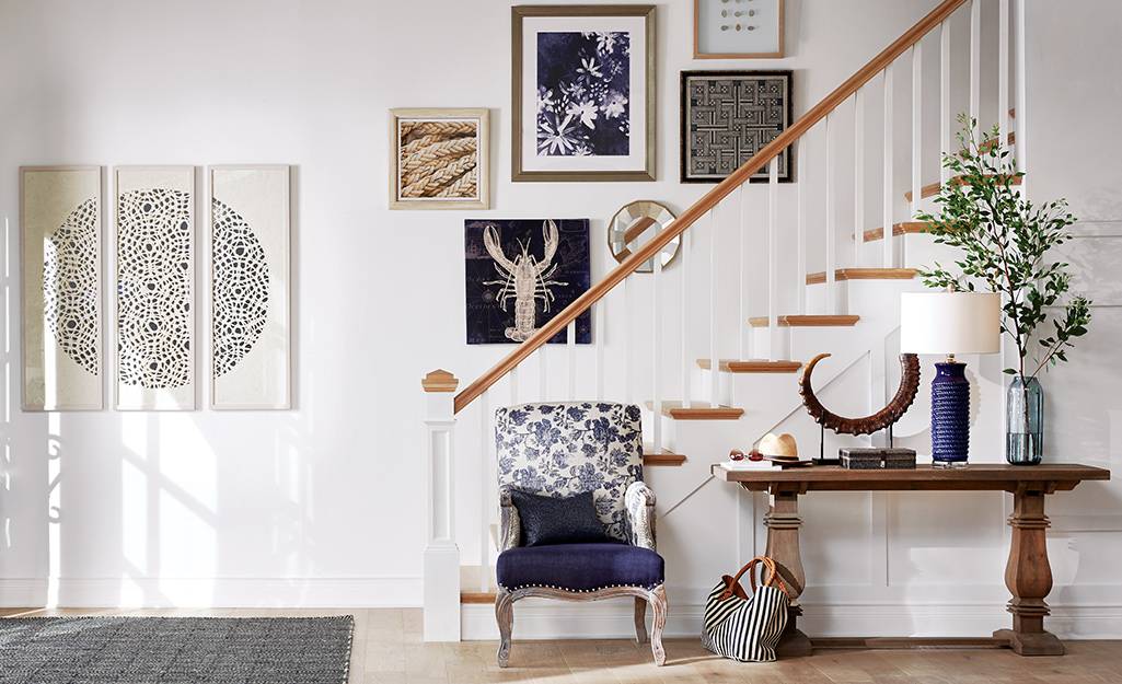 Entryway leading to stairs with a chic chair finished in fabric.