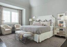 Soft grey romantic master bedroom decor with two sitting chairs.