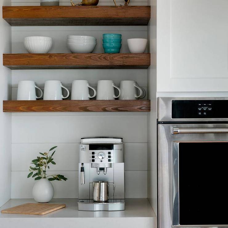 Kitchen features a coffee station under rustic wooden shelves on a white shiplap backsplash.