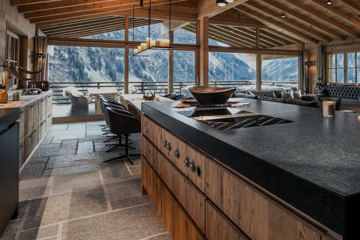 Gorgeous mountain view from the kitchen in a chalet with floor-to-ceiling windows.