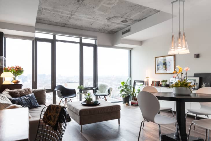 Modern Toronto condo with concrete ceiling, modern furniture, and floor-to-ceiling windows.