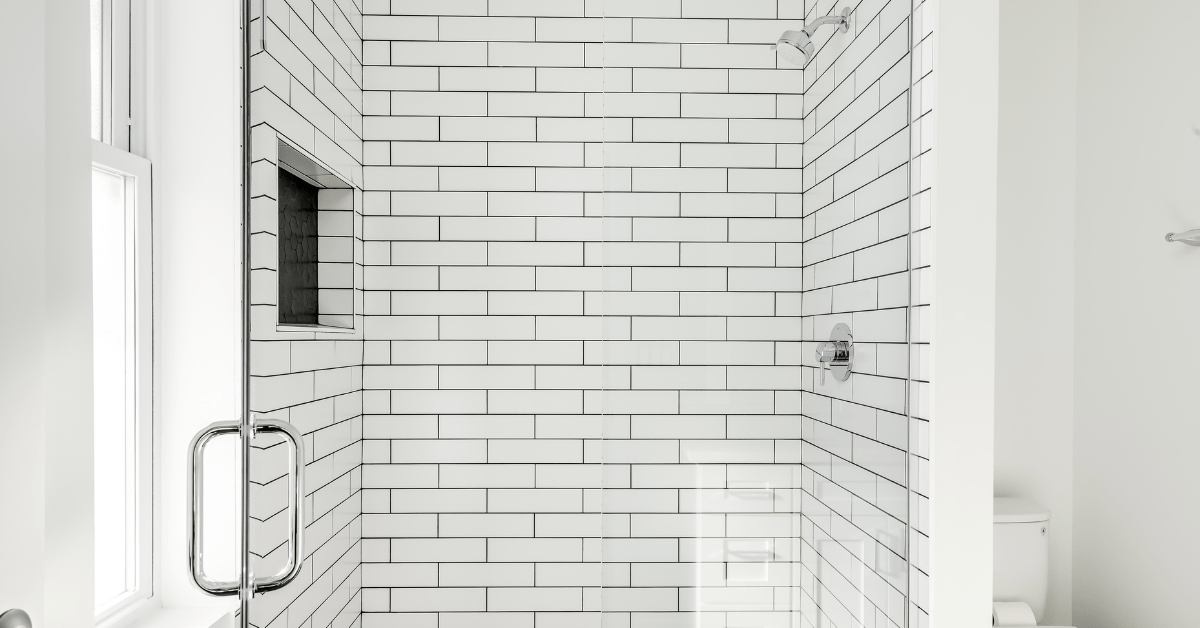 White subway tile shower with stainless steel fixtures.