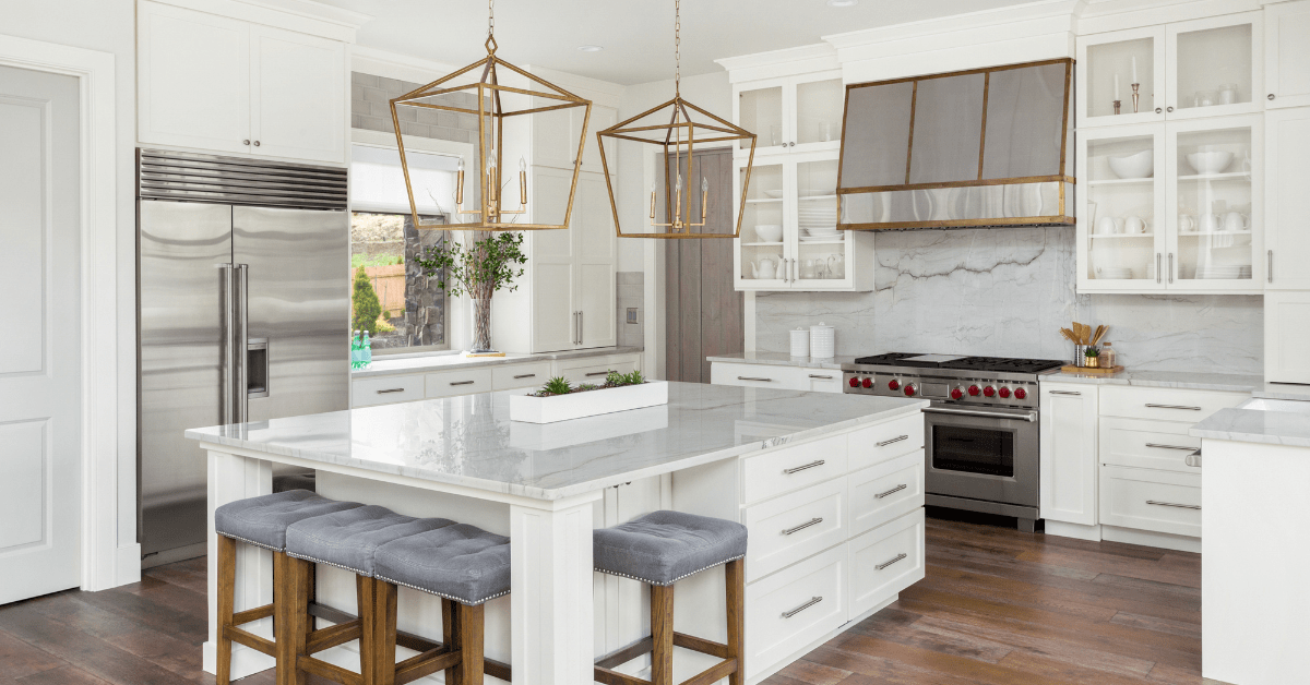 White kitchen with a large island featuring drawers for storage and seating.