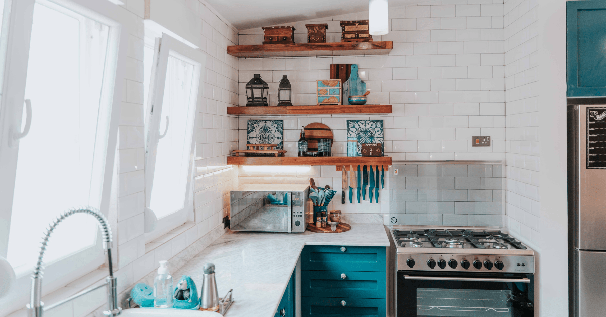 Blue cabinets in a galley kitchen with open-shelf storage.