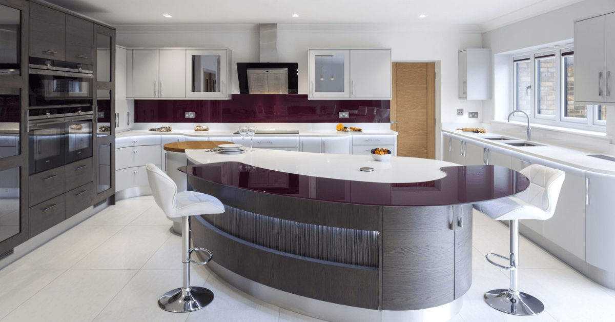 Ultra luxurious and modern kitchen with a curved island featuring white seats.
