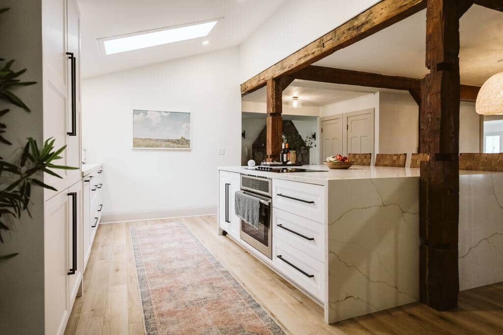 Modern beach house kitchen with minimalist decor and hidden appliances.