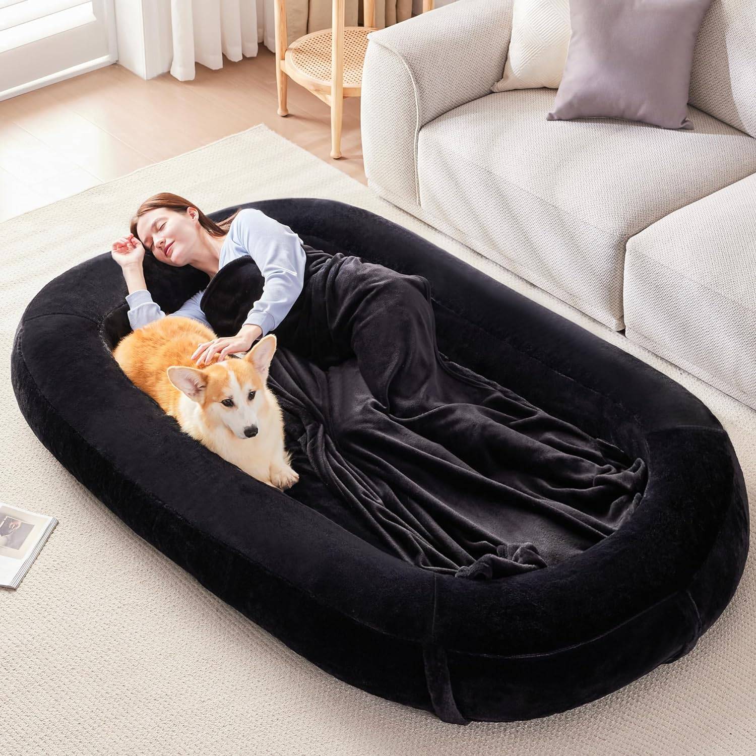 black human dog bed with woman and corgi sleeping in it