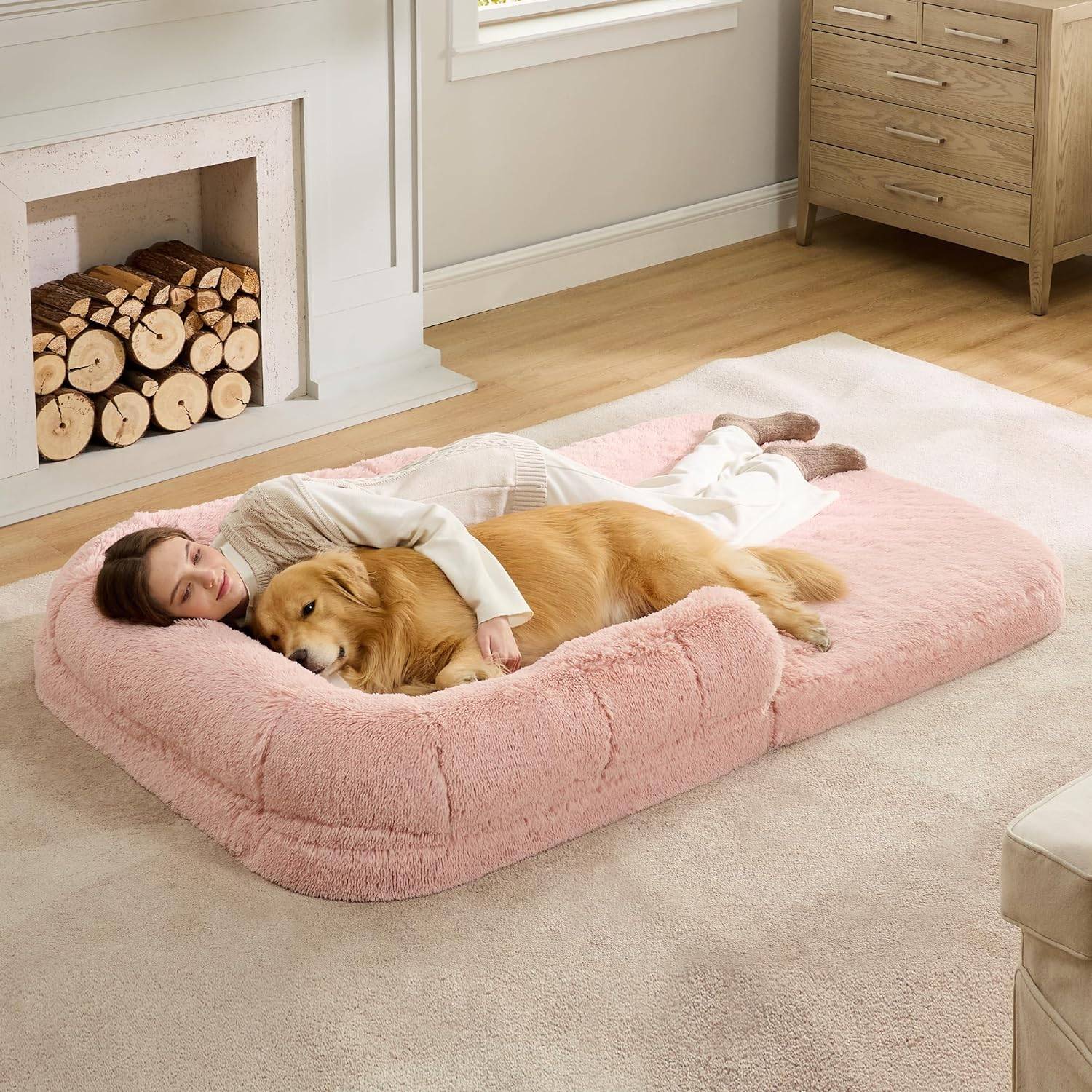 pink fuzzy human dog bed with woman and golden retriever sleeping in it