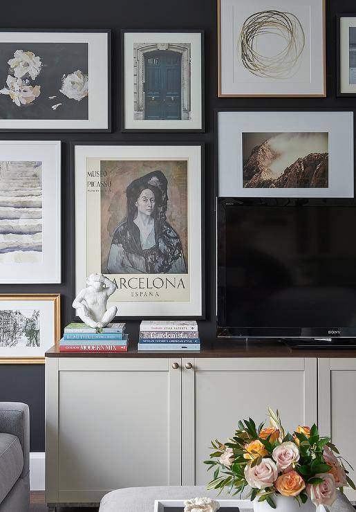 Living room features a TV atop a cream cabinet with an art wall.