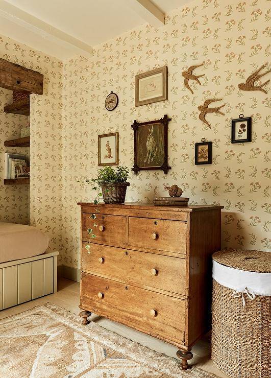 Girl's room features a vintage dresser with vintage rug and a round rattan hamper with lid.